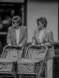 two women pushing strollers in a black and white photo